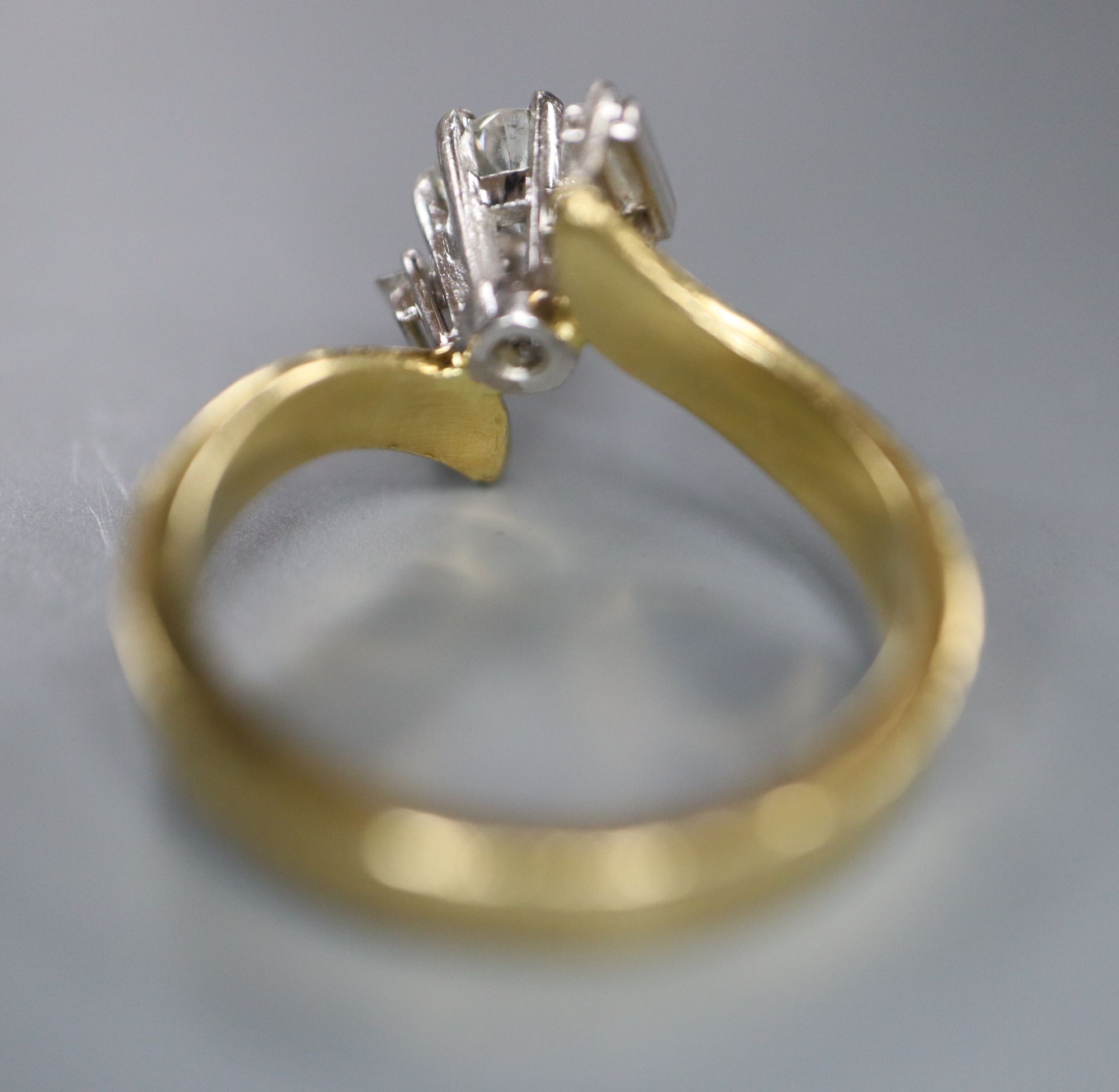 A modern textured 18ct gold and single stone diamond ring, with baguette cut diamond set shoulders,